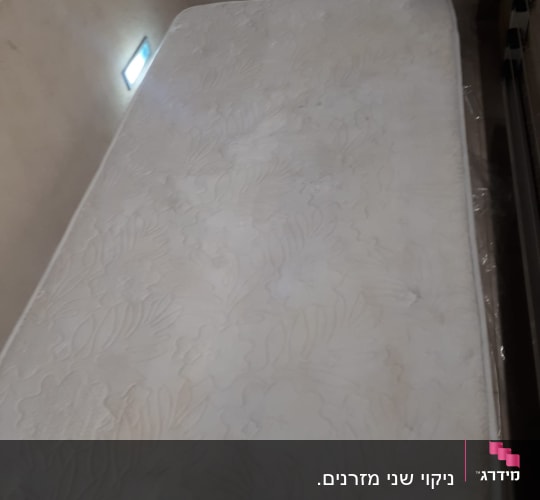 מזרן לבן עם כתמים קלים על פני השטח